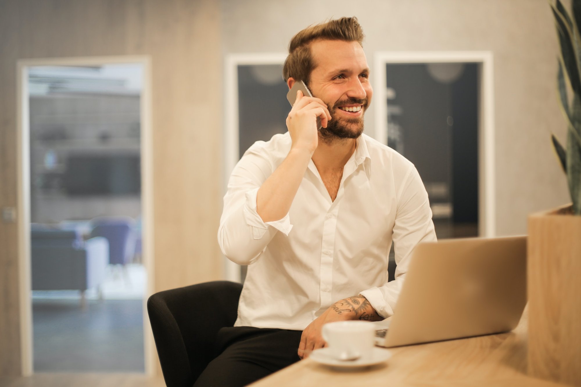 man i vit skjorta pratar i telefon