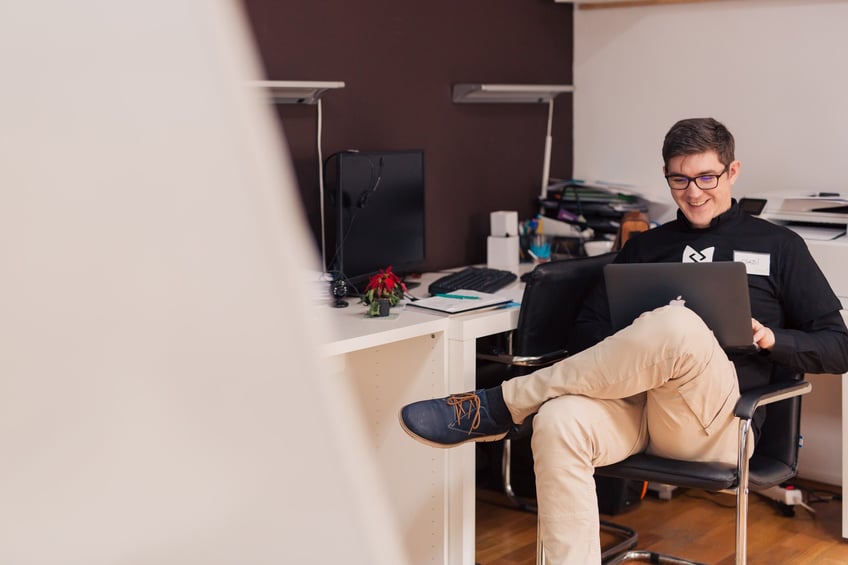 man sitter med laptop i knäet