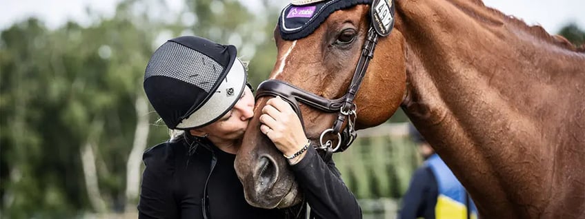 kvinna pussar på häst