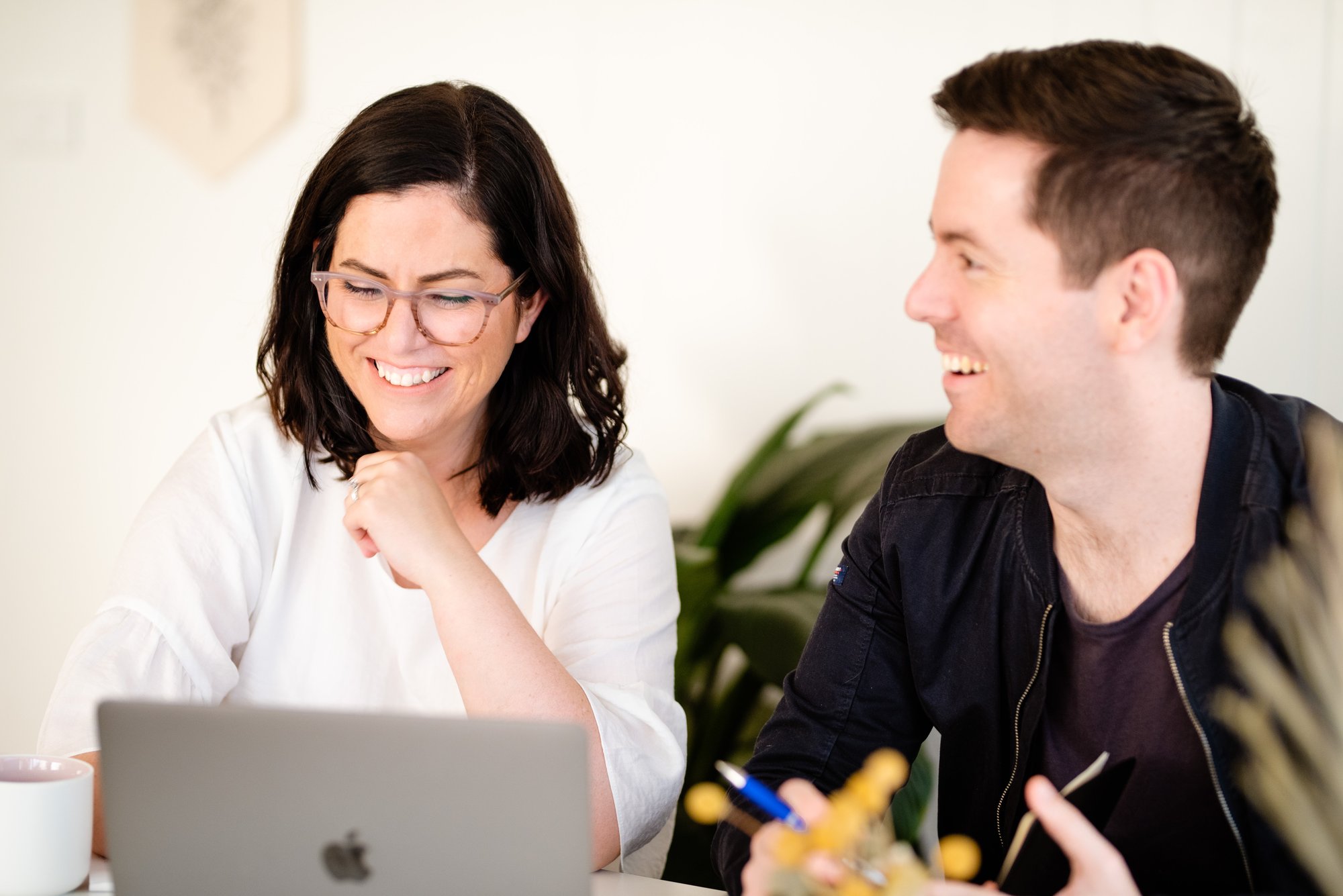Genrebild, en kvinna och en man sitter i ett möte framför en laptop