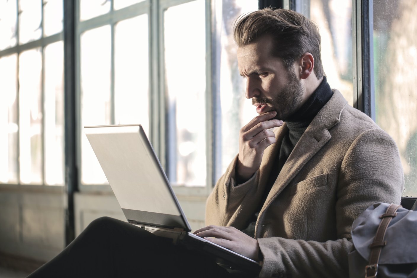 Man sitter framför laptop och ser bekymrad ut