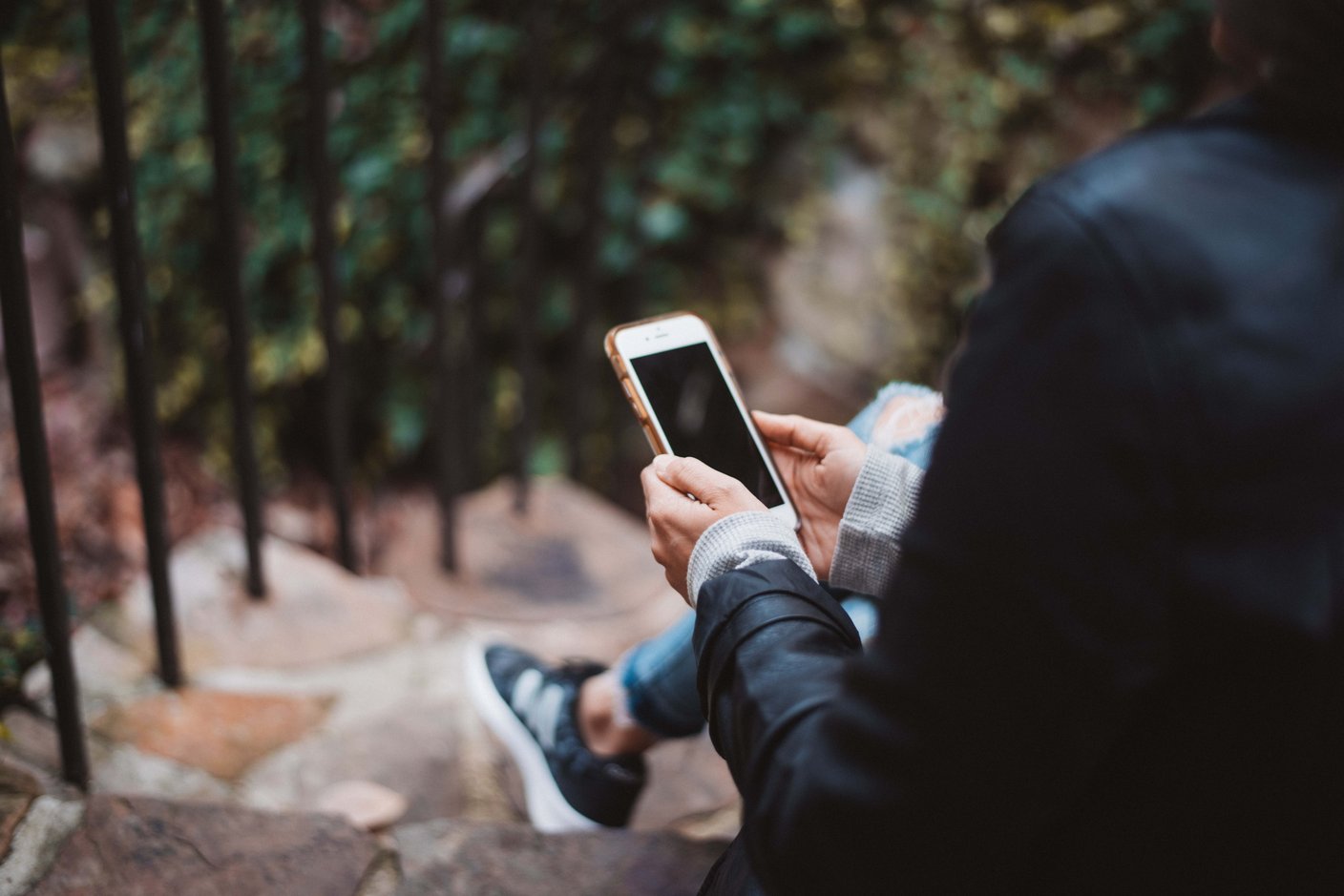person sitter i en trappa och håller i en telefon